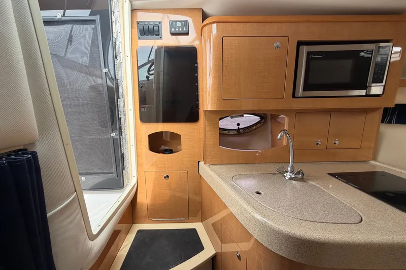 Slide: The Image of Interior of 2011 Four Winns V285 boat featuring kitchenette with sink and microwave. - 47