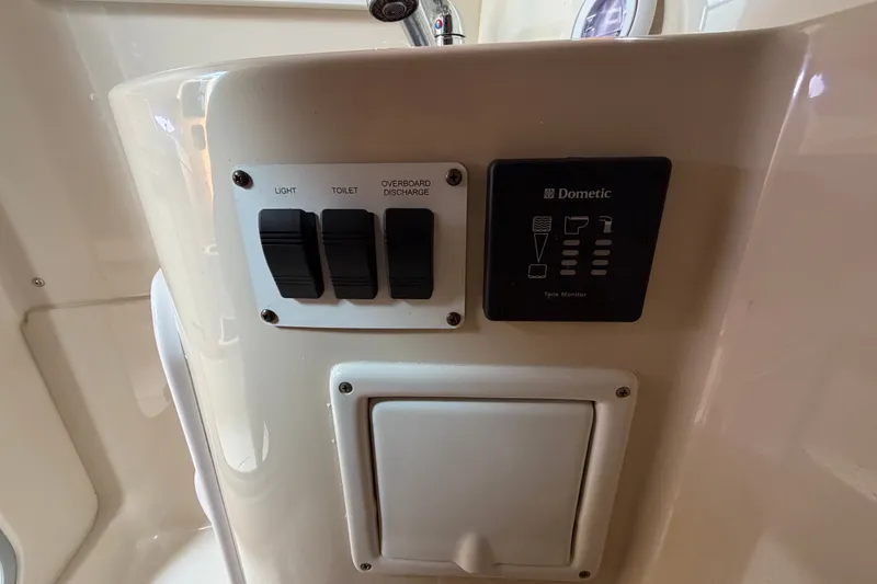 Slide: The Image of Control panel on 2011 Four Winns V285 boat with switches and Dometic tank monitor. - 87