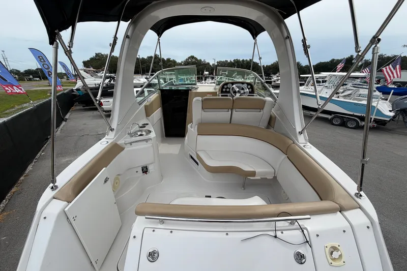Slide: The Image of 2011 Four Winns V285 boat interior with seating and helm, displayed at a marina. - 3