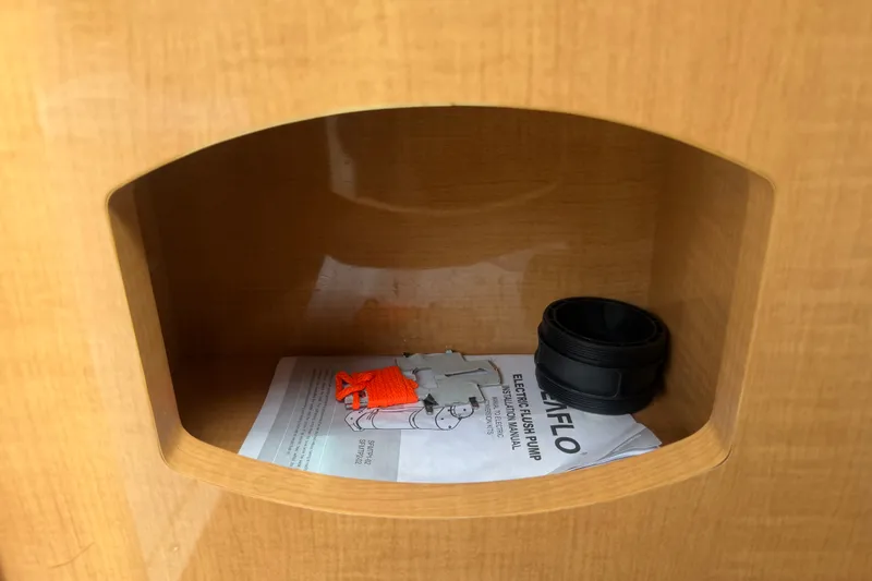 Slide: The Image of Storage compartment in a 2011 Four Winns V285 boat with manual and accessories. - 51