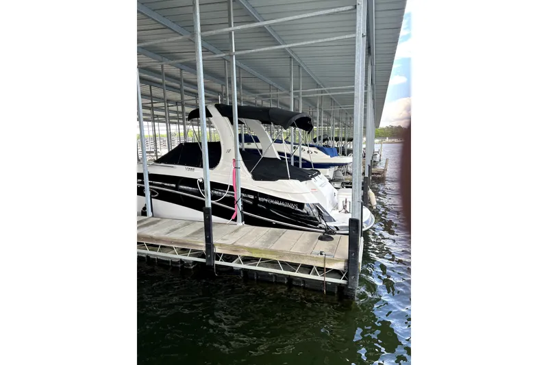 Slide: The Image of 2011 Four Winns V285 boat docked in a covered marina slip. - 2