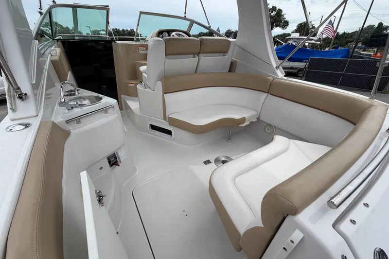 Slide: The Image of 2011 Four Winns V285 boat interior with beige seating and compact kitchenette. - 9