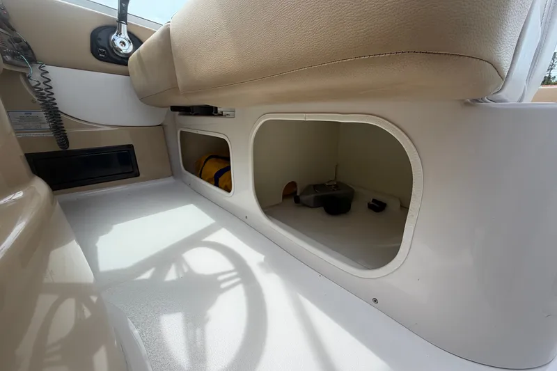 Slide: The Image of Interior storage compartment of a 2011 Four Winns V285 boat, featuring beige seating. - 102