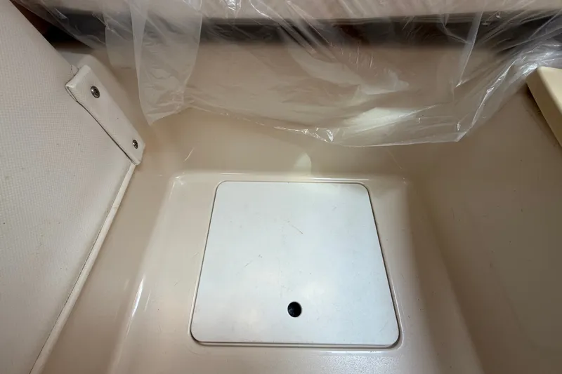 Slide: The Image of Storage compartment on a 2011 Four Winns V285 boat, featuring a secure latch. - 91