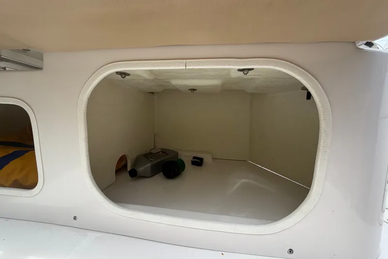 Slide: The Image of Storage compartment of a 2011 Four Winns V285 boat, featuring various items inside. - 103
