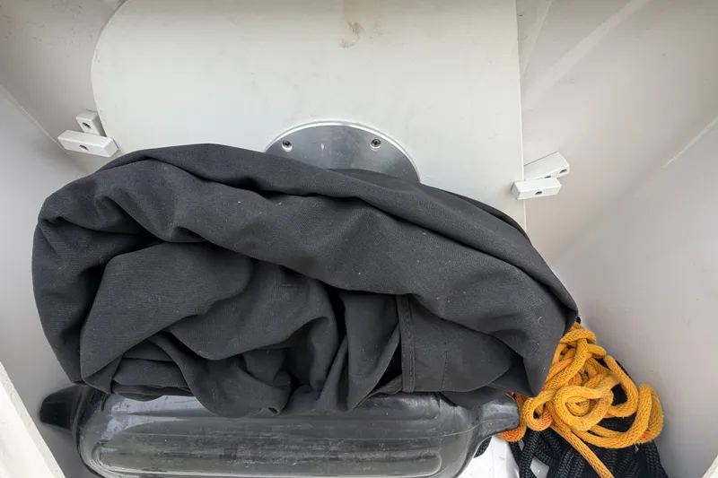 Slide: The Image of Storage compartment in a 2011 Four Winns V285 boat with black cover and yellow rope. - 6