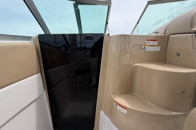Slide: The Image of Interior view of 2011 Four Winns V285 boat, featuring beige seating and steps. - 41