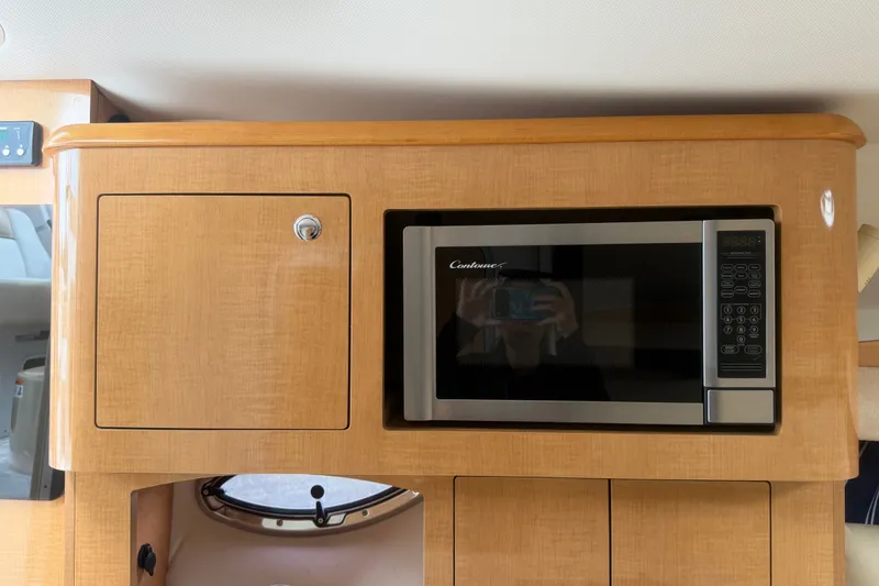 Slide: The Image of 2011 Four Winns V285 interior with microwave and wooden cabinetry. - 57