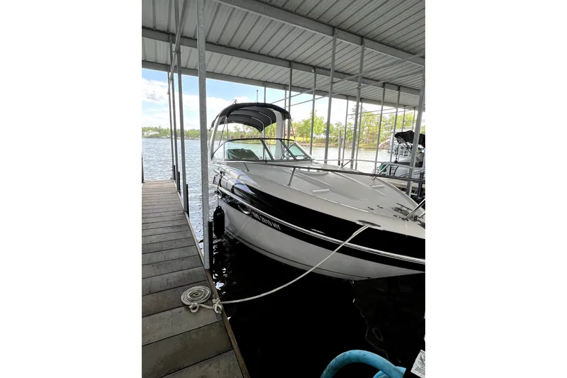 Slide: The Image of 2011 Four Winns V285 boat docked under a covered marina. - 0