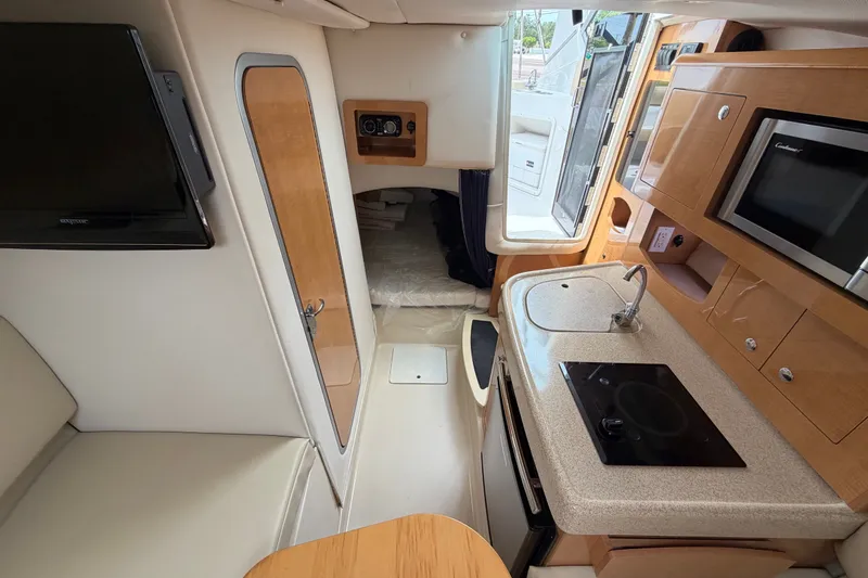 Slide: The Image of Interior of 2011 Four Winns V285 boat with kitchenette and seating area. - 80
