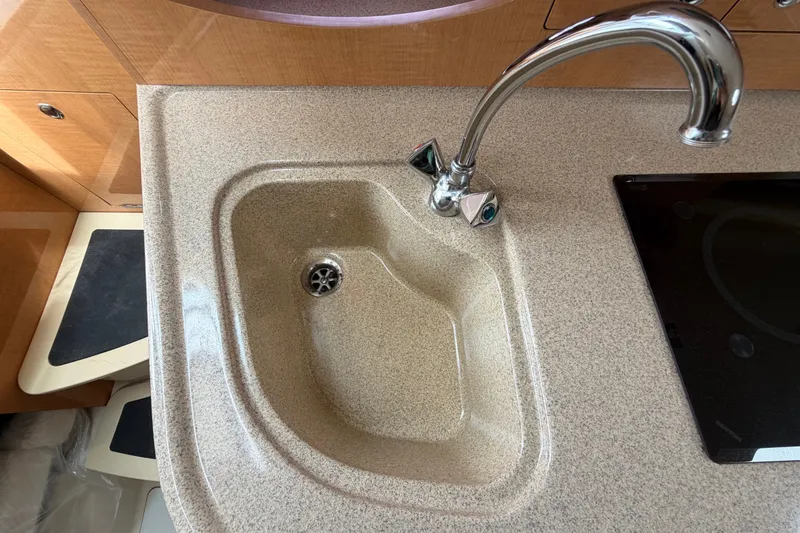 Slide: The Image of Compact kitchen sink and faucet in 2011 Four Winns V285 boat interior. - 63
