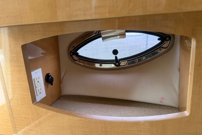 Slide: The Image of 2011 Four Winns V285 cabin interior with oval window and electrical outlet. - 59