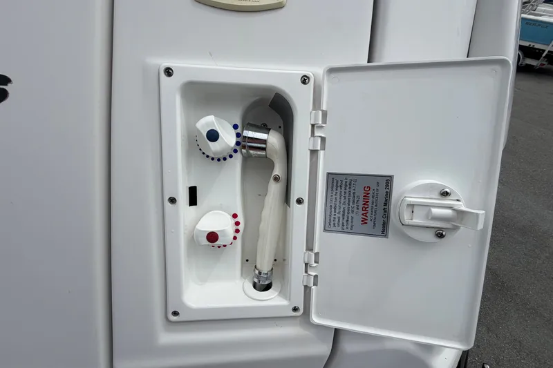 Slide: The Image of 2011 Four Winns V285 boat shower controls with hot and cold water knobs. - 8