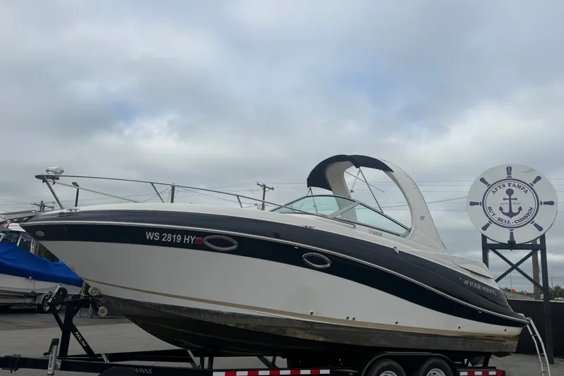 The Image of 2011 Four Winns V285 boat on trailer at a marina with overcast sky. - 0