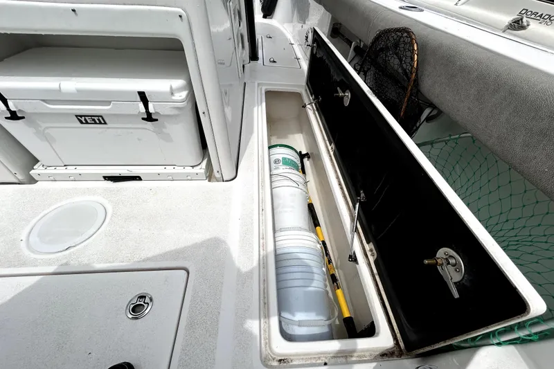 Slide: The Image of 2024 Sea Fox 328 Commander boat storage compartment with Yeti cooler and fishing gear. - 26