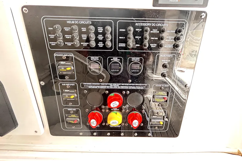Slide: The Image of Control panel of a 2024 Sea Fox 328 Commander boat with various circuit switches. - 48