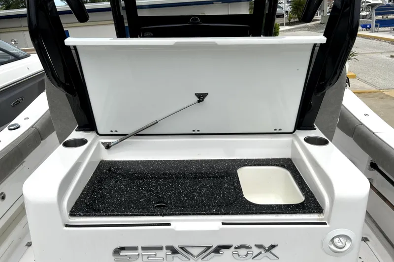 Slide: The Image of 2024 Sea Fox 328 Commander boat with open storage compartment and cup holders. - 21