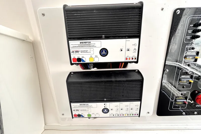 Slide: The Image of 2024 Sea Fox 328 Commander electrical panel with JL Audio amplifiers and control switches. - 71