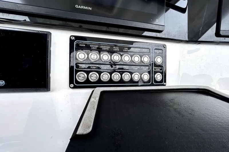 Slide: The Image of Control panel of 2024 Sea Fox 328 Commander boat with various switches and Garmin display. - 32