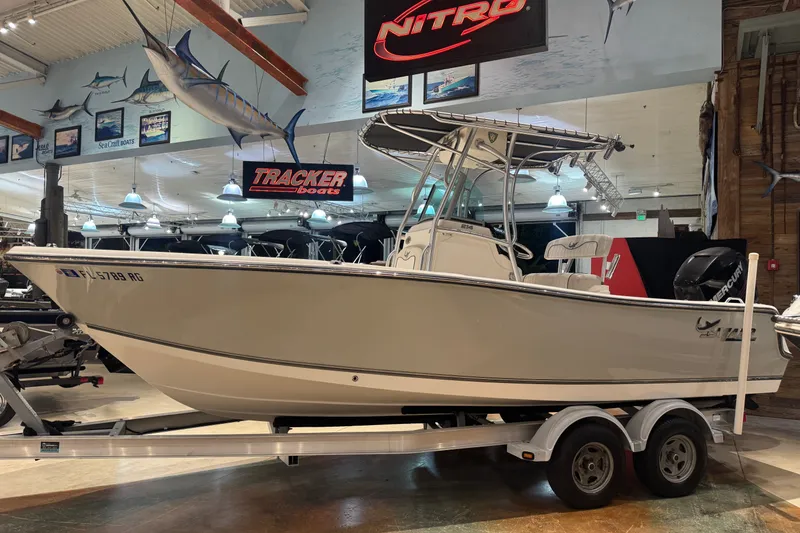 Slide: The Image of 2015 Mako 214 Center Console boat displayed indoors on a trailer. - 2