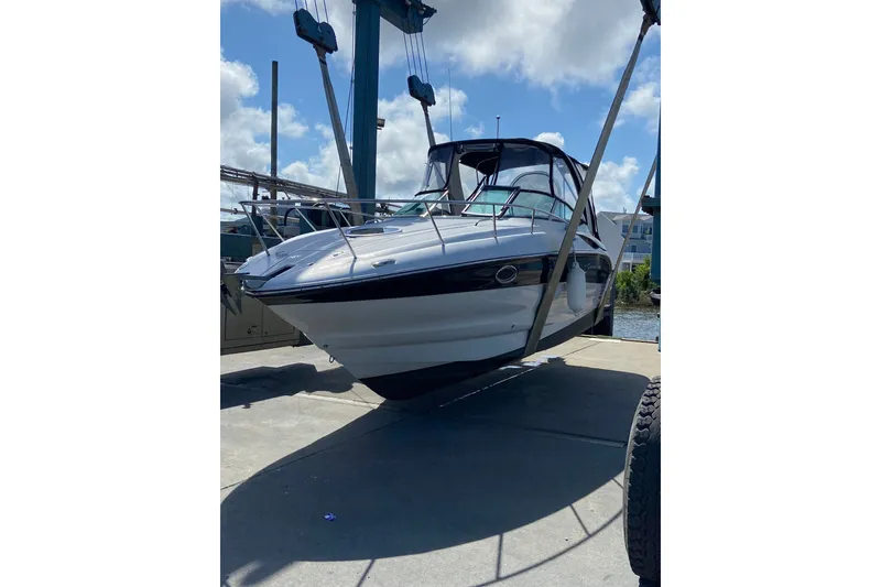 Slide: The Image of 2012 Crownline 260 CR boat suspended on a lift under a clear sky. - 23
