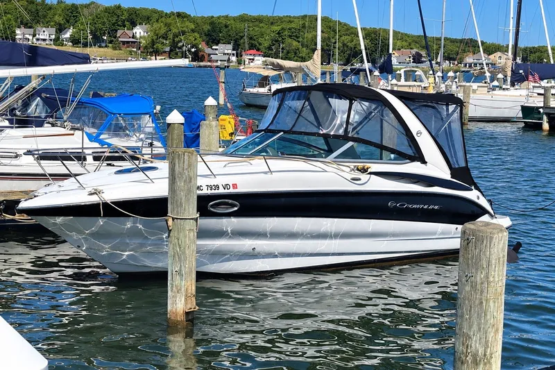 The Image of 2012 Crownline 260 CR boat docked in a marina, surrounded by other vessels. - 0