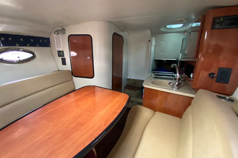 Slide: The Image of Interior of 2012 Crownline 260 CR boat with seating, table, and kitchenette. - 17