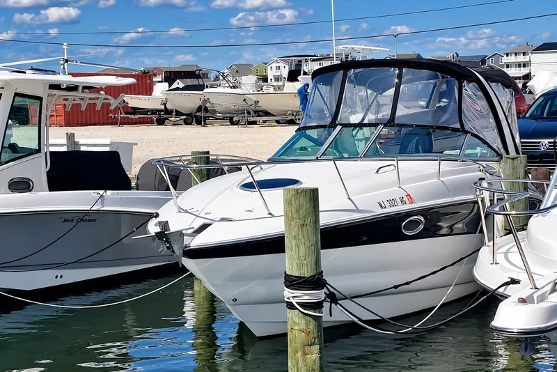 Slide: The Image of 2012 Crownline 260 CR boat docked at marina under clear blue sky. - 2