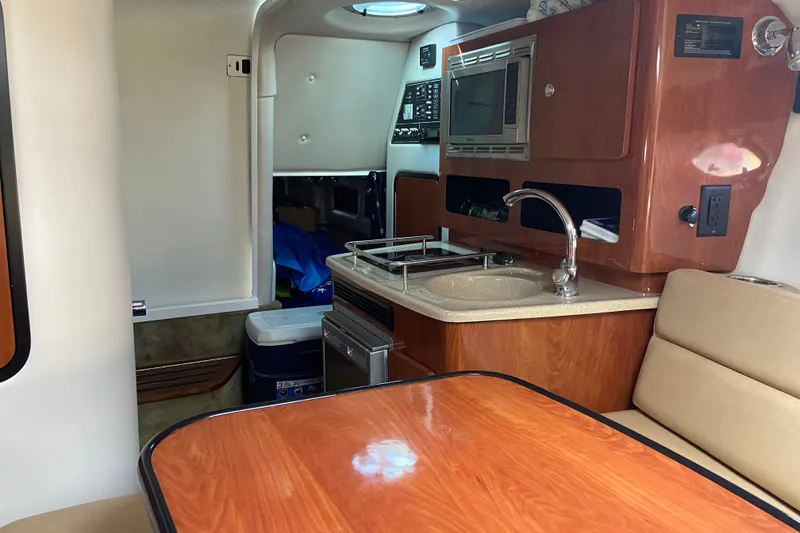 Slide: The Image of Interior of 2012 Crownline 260 CR boat with kitchenette and seating area. - 18