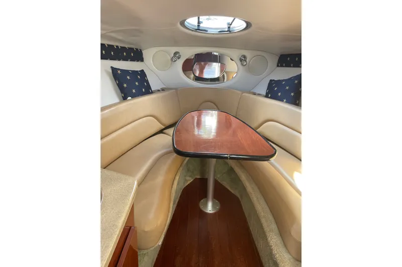 Slide: The Image of Interior of 2012 Crownline 260 CR boat with cozy seating and wooden table. - 11