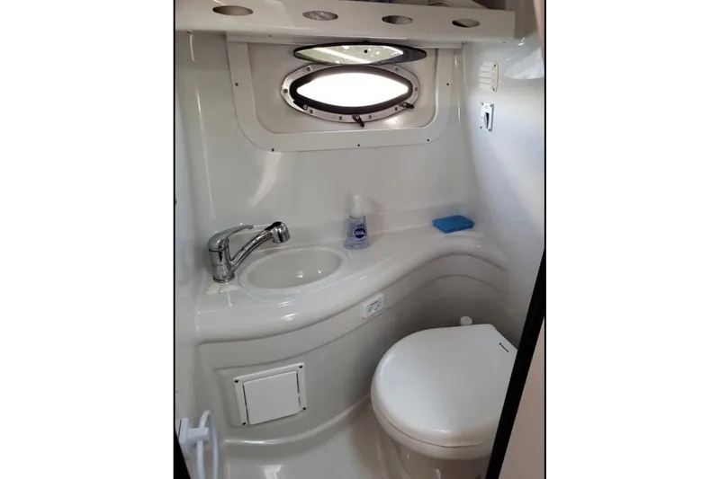 Slide: The Image of Compact bathroom in 2012 Crownline 260 CR boat with sink and toilet. - 20