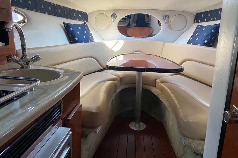 Slide: The Image of Interior of 2012 Crownline 260 CR boat with cozy seating and kitchenette. - 13