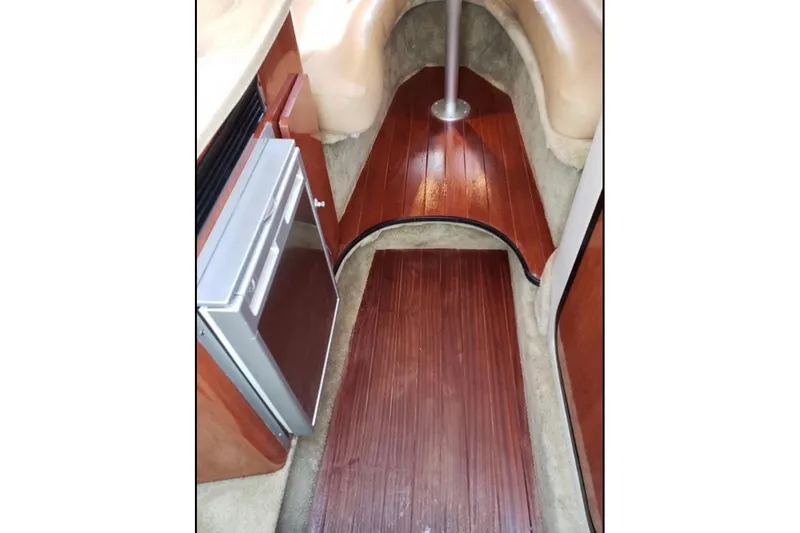 Slide: The Image of Interior of 2012 Crownline 260 CR boat with wood flooring and compact refrigerator. - 14