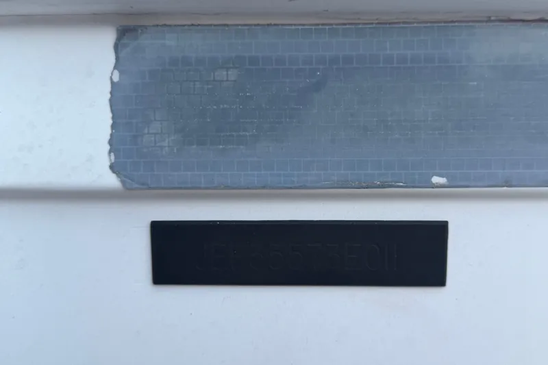 Slide: The Image of Close-up of a Jefferson Marlago FS35 boat detail, showing a worn surface and black label. - 92