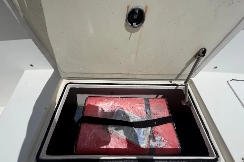 Slide: The Image of Open storage compartment on 2011 Jefferson Marlago FS35 boat with red package inside. - 59