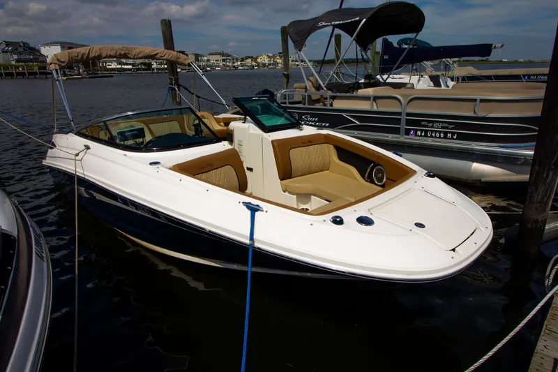 Slide: The Image of Ein Sea Ray 220 Sundeck von 2015 liegt am Dock. Es hat ein beiges Interieur und ein Sonnendach. - 22