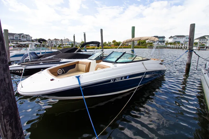 Slide: The Image of Ein Sea Ray 220 Sundeck von 2015 liegt an einem Dock. Es hat ein blau-weißes Design. - 20