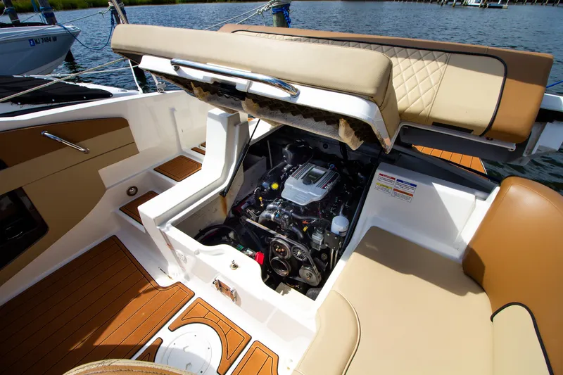 Slide: The Image of Un Sea Ray 220 Sundeck del 2015 con vano motore aperto e tappezzeria beige su un lago. - 37