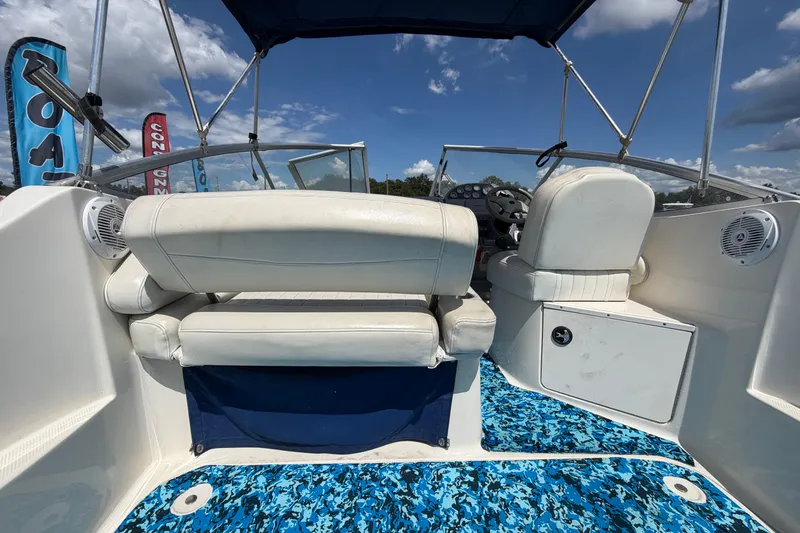 Slide: The Image of 2004 Bayliner 2452 Ciera Express boat interior with white seating and blue patterned flooring. - 14
