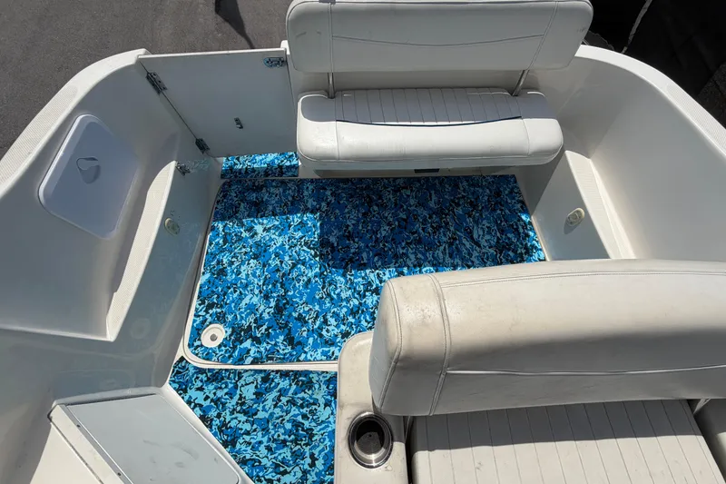 Slide: The Image of 2004 Bayliner 2452 Ciera Express boat interior with blue patterned flooring and white seating. - 73
