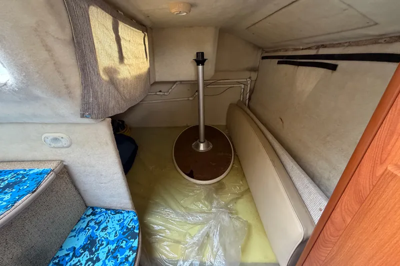 Slide: The Image of Interior cabin of a 2004 Bayliner 2452 Ciera Express boat, featuring seating and table. - 51