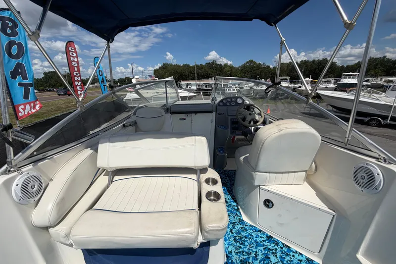 Slide: The Image of 2004 Bayliner 2452 Ciera Express boat interior with seating and steering wheel, under blue canopy. - 17