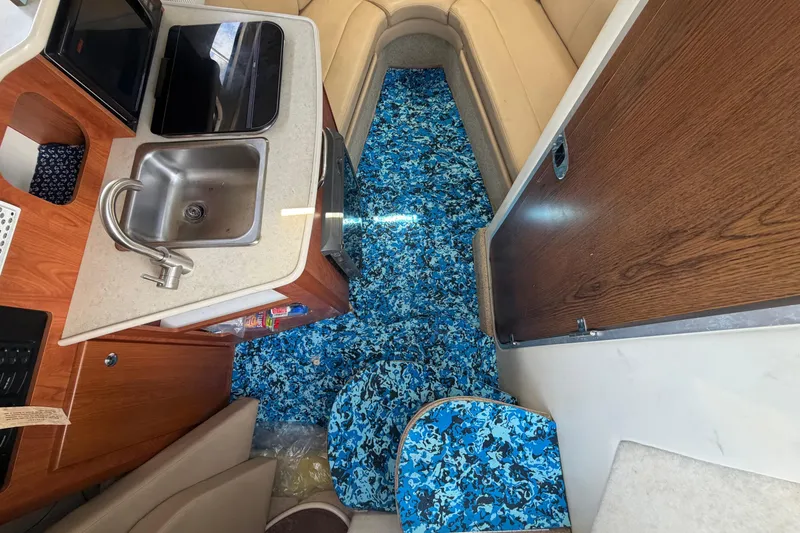 Slide: The Image of Interior del Bayliner 2452 Ciera Express 2004 con cocina y alfombras azules. - 30