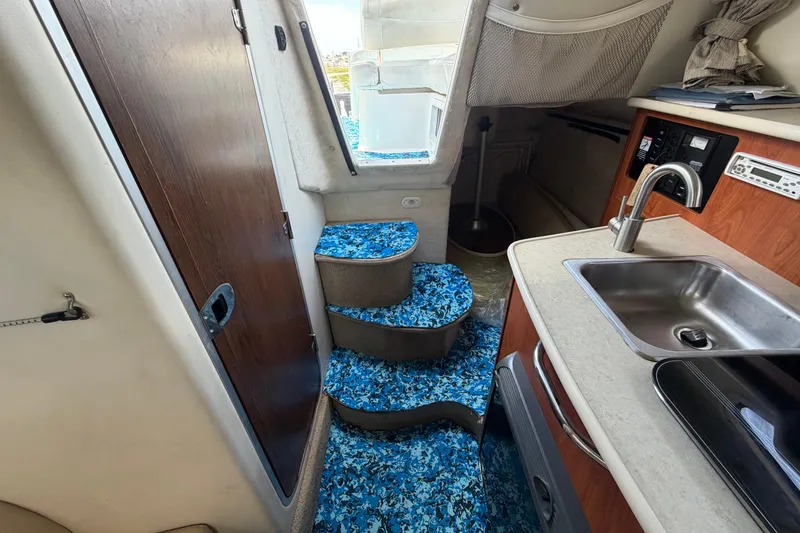 Slide: The Image of Interior of 2004 Bayliner 2452 Ciera Express with blue-patterned steps and kitchenette. - 45