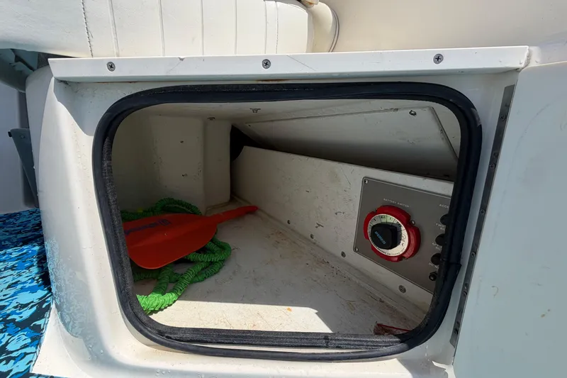Slide: The Image of Storage compartment of 2004 Bayliner 2452 Ciera Express with paddle and battery switch. - 19