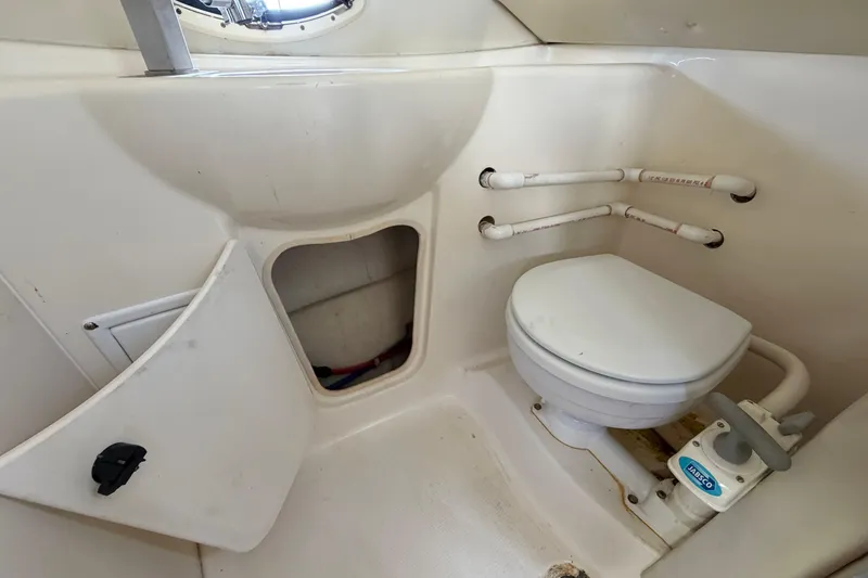 Slide: The Image of 2004 Bayliner 2452 Ciera Express boat bathroom with toilet and storage compartment. - 48