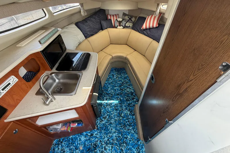 Slide: The Image of Interior of 2004 Bayliner 2452 Ciera Express with kitchenette and cozy seating area. - 31