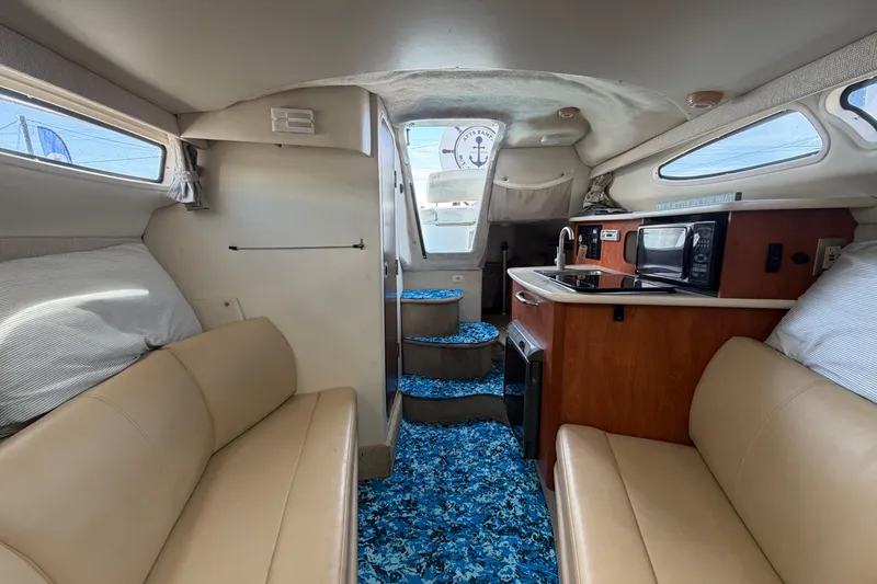 Slide: The Image of Interior of 2004 Bayliner 2452 Ciera Express with seating, kitchenette, and nautical decor. - 57