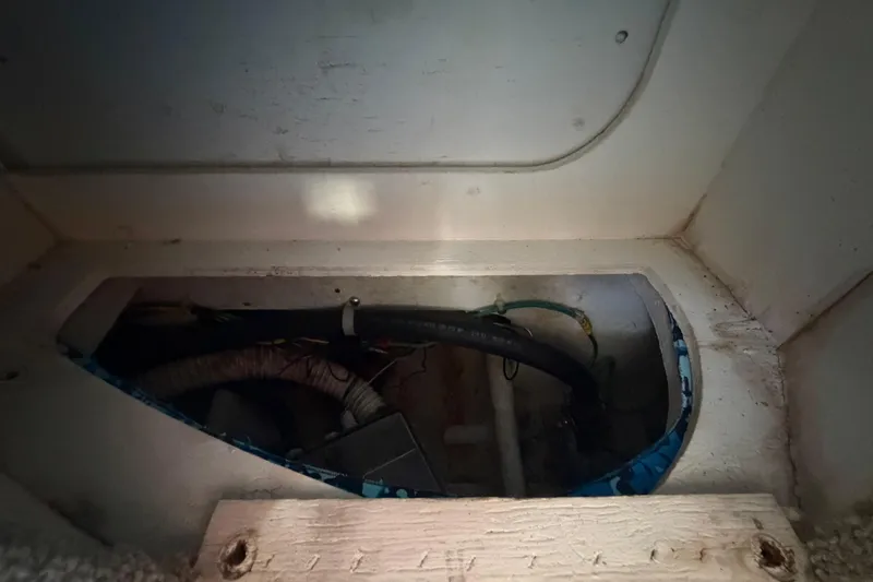 Slide: The Image of 2004 Bayliner 2452 Ciera Express interior compartment with visible wiring and hoses. - 55