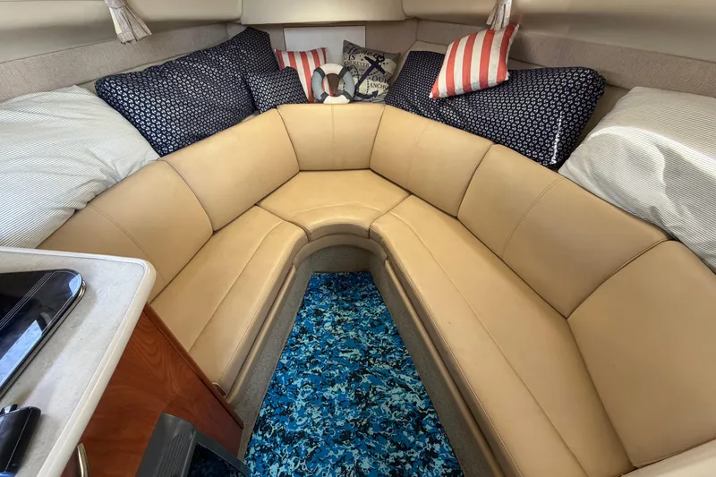 Slide: The Image of 2004 Bayliner 2452 Ciera Express cabin with beige seating and decorative pillows. - 33